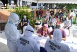 Wisatawan mengantre saat kegiatan tes cepat (rapid test) Swab Antigen COVID-19 secara gratis di kawasan pariwisata Pantai Kuta, Badung, Bali, Sabtu (26/12/2020). Kegiatan yang diselenggarakan Korlantas Polri, Jasa Raharja dan Polda Bali tersebut dilakukan untuk mengantisipasi penyebaran pandemi COVID-19 di destinasi pariwisata selama masa liburan Hari Raya Natal 2020 dan Tahun Baru 2021. ANTARA FOTO/Fikri Yusuf/nym.