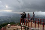 Wisatawan berswafoto saat mengunjungi Gunung Putri Intan Dewata, Tarogong Kaler, Kabupaten Garut, Jawa Barat, Jumat (25/12/2020). Kawasan tersebut menyajikan pemandangan alam Garut dari ketinggian 1.450 mdpl dan menjadi salah satu tujuan wisata pada libur Natal 2020. ANTARA JABAR/Candra Yanuarsyah/agr