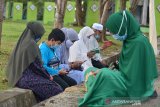 Warga berdoa saat melakukan ziarah di kuburan masal Tsunami, Desa Ulee Lheue, Banda Aceh, Aceh, Sabtu (26/12/2020). Peringatan 16 tahun bencana gempa dan tsunami pada 26 Desember di tengah pandemi COVID-19 itu tetap berlang secara sederhana menerapkan protokol kesehatan dengan rangkaian kegiatan ziarah kubur, tausyiah dan menyantuni yatim. Aantara Aceh/Ampelsa.