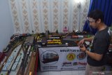 Perakit diorama stasiun kereta api Alvin Setya Patria mengoperasikan miniatur kereta api menggunakan remote control pada diorama produksinya di Kota Madiun, Jawa Timur, Sabtu (26/12/2020). Menurut dia, miniatur kereta, papan displai dan diorama hasil produksinya yang sebagian komponen merupakan buatan pabrik tersebut dijual dengan harga antara Rp350 ribu hingga Rp4 juta, tergantung kelengkapannya. Antara Jatim/Siswowidodo/mas.