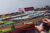 Perakit diorama stasiun kereta api Alvin Setya Patria mengoperasikan miniatur kereta api menggunakan remote control pada diorama produksinya di Kota Madiun, Jawa Timur, Sabtu (26/12/2020). Menurut dia, miniatur kereta, papan displai dan diorama hasil produksinya yang sebagian komponen merupakan buatan pabrik tersebut dijual dengan harga antara Rp350 ribu hingga Rp4 juta, tergantung kelengkapannya. Antara Jatim/Siswowidodo/mas.