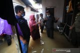 Gubernur Kalsel Sahbirin Noor (kanan) berbincang dengan warga saat meninjau lokasi banjir di Kabupaten Banjar, Kalimantan Selatan, Selasa (29/12/2020). Gubernur bersama jajaran Badan Penanggulangan Bencana Daerah (BPBD) Kalsel dan Satuan Polisi Pamong Praja (Satpol PP) Kalsel meninjau lokasi banjir dari Desa Teluk Selong Ulu Kecamatan Martapura Barat sampai Desa Pekauman Kecamatan Martapura Timur dengan berjalan kaki. Foto Antaranews Kalsel/HO-Infuz MC Kalsel/Bay.