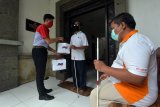 Petugas JNE memberikan sembako kepada penyandang tunanetra dalam program berbagi kebahagiaan di Denpasar, Bali, Rabu (30/12/2020). Kegiatan tersebut untuk membantu penyandang tunanetra yang bekerja sebagai tukang pijat terdampak pandemi COVID-19. ANTARA FOTO/Nyoman Hendra Wibowo/nym.