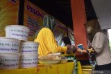 Penjual makanan melayani pembeli di sebuah stand saat peluncuran Lapak Kampung Pesona di Kelurahan Madiun Lor, Kota Madiun, Jawa Timur, Rabu (30/12/2020). Pemkot Madiun bersama pelaku Usaha Mikro Kecil Menengah (UMKM) membuat lapak di setiap kelurahan sebagai pusat kegiatan perekonomian masyarakat setempat. Antara Jatim/Siswowidodo/Um