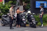 Petugas keamanan menegur wisatawan saat sembarangan memarkir kendaraannya di kawasan Pantai Kuta, Badung, Bali, Kamis (31/12/2020). Polresta Denpasar melakukan rekayasa lalu lintas pada Kamis (31/12/2020) pukul 06.00 WITA hingga Jumat (1/1/2021) pukul 18.00 WITA dengan tidak mengizinkan kendaraan parkir di sepanjang jalan Pantai Kuta untuk mencegah terjadinya kerumunan di kawasan objek wisata itu. ANTARA FOTO/Nyoman Hendra Wibowo/nym.