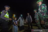 Petugas Kepolisian dan TNI menegur pengunjung yang masih memasuki kawasan wisata Patung Bekantan di Banjarmasin, Kalimantan Selatan, Kamis (31/12/2020). Jelang akhir tahun pengawasan terhadap tempat wisata di Kota Banjarmasin di perketat agar tidak terjadi kerumunan dan mencegah penyebaran COVID-19. Foto Antaranews Kalsel/Bayu Pratama S.