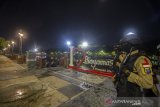 Petugas kepolisian berjaga saat malam pergantian tahun di kawasan wisata siring sungai Martapura di Banjarmasin, Kalimantan Selatan, Kamis (31/12/2020) malam. Pemerintah Kota Banjarmasin menutup sejumlah tempat wisata pada malam pergantian tahun untuk mencegah kerumunan warga.Foto Antaranews Kalsel/Bayu Pratama S.