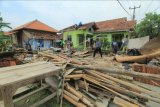 Sejumlah warga memperbaiki rumah yang rusak akibat angin puting beliung di desa Slangit, Kecamatan Klangenan, Kabupaten Cirebon, Jawa Barat, Minggu (3/1/2021). Angin puting beliung yang terjadi pada Sabtu (2/1) sore itu menyebabkan sedikitnya 275 rumah warga mengalami kerusakan. ANTARA FOTO/Dedhez Anggara/nym.