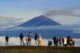 Pengunjung berada di tempat wisata Bukit Tirai Embun dengan latar Gunung Kerinci, Jambi, Minggu (3/1/2021). Meski ditutup sejak 24 Desember 2020 hingga 5 Januari 2021 guna mengantisipasi penyebaran COVID-19, tempat wisata yang menawarkan panorama Gunung Kerinci, hamparan awan, dan gugusan perbukitan Danau Gunung Tujuh tersebut tetap didatangi pengunjung. ANTARA FOTO/Wahdi Septiawan/aww.