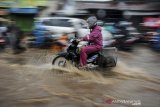 Kendaraan menerjang air yang menggenangi Jalan Raya Cinunuk, Kabupaten Bandung, Jawa Barat, Senin (4/1/2021). Genangan air setinggi 10 hingga 50 sentimeter menggenangi Jalan Nasional menuju Sumedang, Tasik dan Garut akibat drainase yang buruk sehingga tidak dapat menampung debit air secara maksimal saat hujan lebat mengguyur kawasan Bandung Raya. ANTARA JABAR/Raisan Al Farisi/agr