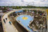 Pengunjung melintas di jembatan Antasan Bromo di Banjarmasin, Kalimantan Selatan, Senin (4/1/2021). Pemerintah Kota Banjarmasin meresmikan kawasan ekowisata, Jembatan Antasan Bromo dengan panjang 168 meter dan lebar dua meter, selain berfungsi sebagai infrastruktur penghubung antar kampung tersebut juga menjadi salah satu ikon Kota dan tempat wisata baru Kota Banjarmasin. Foto Antaranews Kalsel/Bayu Pratama S.