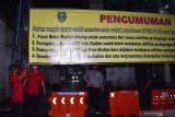 Petugas memasang spanduk pengumuman penutupan sementara Pasar Besar Kota Madiun, Jawa Timur, Sabtu (2/1/2021) malam. Penutupan sementara pasar pasar terbesar di Kota Madiun tersebut dilakukan untuk pencegahan penularan COVID-19 menyusul adanya puluhan orang dinyatakan positif COVID-19 berdasarkan hasil tes usap PCR dan beberapa orang diantaranya dikabarkan meninggal dunia. Antara Jatim/Siswowidodo/zk