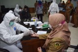 Petugas kesehatan mengambil sampel darah Aparatur Sipil Negara (ASN) saat tes diagnostik cepat (rapid test) COVID-19 secara massal di Pemkab Madiun, Jawa Timur, Senin (4/1/2021). Pemkab Madiun menggelar rapid test bagi seluruh ASN di kantor Pusat Pemerintahan Pemkab Madiun guna mencegah penularan penyakit yang disebabkan virus corona menyusul banyaknya kasus positif COVID-19 secara nasional. Antara Jatim/Siswowidodo/zk