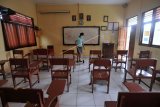 Pegawai sekolah membersihkan ruangan kelas di salah satu SMK di Badung, Bali, Selasa (5/1/2021). Kegiatan pembelajaran secara tatap muka di wilayah Kabupaten Badung yang awalnya direncanakan dimulai pada awal bulan Januari 2021 ditunda sampai batas waktu yang belum ditentukan akibat masih tingginya perkembangan kasus COVID-19. ANTARA FOTO/Fikri Yusuf/nym.