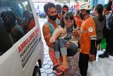 Relawan menggendong pengungsi disabilitas saat tiba di tempat pengungsian gunung Merapi Desa Banyurojo, Magelang, Jawa Tengah, Selasa (5/1/2021). Seiring meningkatnya aktivitas vulakanik gunung Merapi ratusan warga kelompok rentan yakni lansia, anak-anak, ibu hamil dan penyandang disabilitas yang berada di kawasan rawan bencana kembali mengungsi setelah sebelumnya pulang karena bosan di pengungsian. ANTARA FOTO/Anis Efizudin/nym.