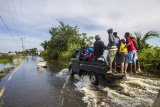 Sejumlah warga menggunakan mobil bak terbuka untuk melintas di Jalan Martapura lama yang terendam banjir di Desa Sungai Rangas Ulu, Kabupaten Banjar, Kalimantan Selatan, Rabu (6/1/2021). Menurut Badan Penanggulangan Bencana Daerah (BPBD) Kabupaten Banjar, banjir setinggi lima hingga satu meter yang melanda pemukiman di sejumlah desa di Kabupaten Banjar tersebut dipicu oleh hujan dengan intensitas tinggi sehingga menyebabkan debit air sungai Martapura meluap. Foto Antaranews Kalsel/Bayu Pratama S.