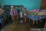 Warga beraktivitas di dalam rumahnya yang terendam banjir di Desa Sungai Rangas Ulu, Kabupaten Banjar, Kalimantan Selatan, Rabu (6/1/2021). Menurut Badan Penanggulangan Bencana Daerah (BPBD) Kabupaten Banjar, banjir setinggi lima hingga satu meter yang melanda pemukiman di sejumlah desa di Kabupaten Banjar tersebut dipicu oleh hujan dengan intensitas tinggi sehingga menyebabkan debit air sungai Martapura meluap. Foto Antaranews Kalsel/Bayu Pratama S.