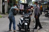 Petugas menghentikan warga yang tidak mengenakan masker di Dukuh Setro, Surabaya, Jawa Timur, Rabu (6/1/2021). Operasi protokol kesehatan itu menjaring sedikitnya 34 pelanggar yang tidak mengenakan masker dengan benar dan tidak mengenakan masker sama sekali dan para pelanggar dikenakan sanksi denda. Antara Jatim/Didik/Zk