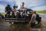 Sejumlah warga menggunakan mobil bak terbuka untuk melintas di Jalan Martapura lama yang terendam banjir di Desa Sungai Rangas Ulu, Kabupaten Banjar, Kalimantan Selatan, Rabu (6/1/2021). Menurut Badan Penanggulangan Bencana Daerah (BPBD) Kabupaten Banjar, banjir setinggi lima hingga satu meter yang melanda pemukiman di sejumlah desa di Kabupaten Banjar tersebut dipicu oleh hujan dengan intensitas tinggi sehingga menyebabkan debit air sungai Martapura meluap. Foto Antaranews Kalsel/Bayu Pratama S.