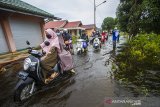 Warga melintasi banjir di Kabupaten Banjar, Kalimantan Selatan, Rabu (6/1/2021). Menurut Badan Penanggulangan Bencana Daerah (BPBD) Kabupaten Banjar, banjir setinggi lima hingga satu meter yang melanda pemukiman di sejumlah desa di Kabupaten Banjar tersebut dipicu oleh hujan dengan intensitas tinggi sehingga menyebabkan debit air sungai Martapura meluap. Foto Antaranews Kalsel/Bayu Pratama S.