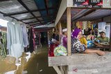 Sejumlah warga beraktivitas di depan rumah yang terendam banjir di Desa Sungai Rangas Ulu, Kabupaten Banjar, Kalimantan Selatan, Rabu (6/1/2021). Menurut Badan Penanggulangan Bencana Daerah (BPBD) Kabupaten Banjar, banjir setinggi lima hingga satu meter yang melanda pemukiman di sejumlah desa di Kabupaten Banjar tersebut dipicu oleh hujan dengan intensitas tinggi sehingga menyebabkan debit air sungai Martapura meluap.Foto Antaranews Kalsel/Bayu Pratama S.