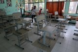 Pegawai sekolah merapikan ruang kelas di SMK.N 1 Bengkulu, Rabu (6/1/2021). Berdasarkan keputusan Pemprov Bengkulu dan Satgas Penanganan Covid-19 pelaksanaan belajar tatap muka pada semester genap tahun 2021 ditunda sampai batas waktu yang belum ditentukan karena kasus Covid-19 di daerah ini terus meningkat. ANTARA FOTO/David Muharmansyah/18