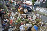 Pengendara melaju di samping tumpukan sampah di tempat penampungan sampah sementara di Jalan Karimata, Jember, Jawa Timur, Rabu (6/1/2021). Tumpukan sampah di sejumlah titik di Jember terkait mogoknya 32 truk pengangkut sampah akibat tidak ada anggaran operasional BBM. Antara Jatim/Seno/zk