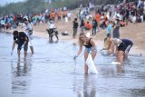 Relawan membersihkan sampah yang berserakan saat mengikuti aksi bersih sampah di Pantai Kuta, Badung, Bali, Rabu (6/1/2021). Kegiatan yang diikuti ratusan orang dari berbagai unsur masyarakat tersebut dilakukan untuk membersihkan sampah kiriman yang terbawa arus gelombang laut dan terdampar kawasan Pantai Kuta yang mengganggu aktivitas warga serta wisatawan. ANTARA FOTO/Fikri Yusuf/nym.