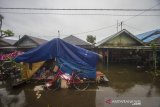 Warga berada di tenda darurat di depan rumahnya yang terendam banjir akibat luapan Sungai Martapura di Desa Sungai Rangas Ambuku, Kabupaten Banjar, Kalimantan Selatan, Kamis (7/1/2021). Menurut warga setempat, banjir akibat luapan Sungai Martapura sudah berlangsung selama 15 hari merendam kawasan tersebut sehingga mengganggu aktivitas warga, dan hingga Kamis (7/1/2021) pemerintah daerah belum memberikan bantuan apapun. Foto Antaranews Kalsel/Bayu Pratama S.