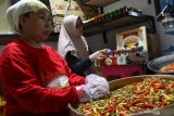 Heni Wardhani (kiri) bersama pekerjanya membuat sambal kemasan untuk dikirim ke Turki, Malaysia dan Hongkong di rumah produksi Sambal Mama Ni di Pandanwangi, Malang, Jawa Timur, Kamis (7/1/2021). Pengusaha sambal kemasan setempat berusaha mengatasi pembengkakan biaya produksi akibat mahalnya cabai rawit yang mencapai Rp90 ribu per kilogram dengan mencari bahan baku hingga ke pelosok desa serta menggenjot penjualan melalui pasar digital agar bisa menutup biaya dengan cepat. Antara Jatim/Ari Bowo Sucipto/zk