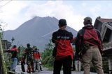 Sejumlah relawan memantau perkembangan aktivitas gunung Merapi di Babadan 2, Paten, Dukun, Magelang, Jawa Tengah, Kamis (7/1/2021). Balai Penyelidikan dan Pengembangan Teknologi Kebencanaan Geologi (BPPTKG) melalui situs resminya menyampaikan terjadi guguran awan panas pada Kamis (7/1/2021) pukul 12.50 WIB tercatat di seismogram dengan amplitudo 21 mm dan durasi 139 detik tinggi kolom teramati 200 m di atas puncak, jarak luncur sekitar 300 meter ke arah hulu Kali Krasak. ANTARA FOTO/Anis Efizudin/nym.