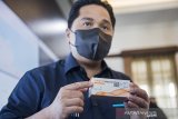 Menteri Badan Usaha Milik Negara (BUMN) Erick Thohir menunjukkan kemasan vaksin COVID-19 saat kunjungan kerja di Command Center serta Sistem Manajemen Distribusi Vaksin (SMDV) di Bio Farma, Bandung, Jawa Barat, Kamis (7/1/2021). Kunjungan tersebut dalam rangka memantau dan memastikan proses pengiriman vaksin COVID-19 ke seluruh Indonesia terpantau secara baik dan real time. ANTARA JABAR/M Agung Rajasa/agr