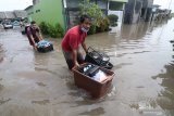 Warga menyelamatkan barang miliknya saat banjir di Desa Kwadungan, Kediri, Jawa Timur, Kamis (7/1/2021). Ratusan rumah di wilayah itu terendam banjir usai hujan deras dan meluapnya sungai yang membawa air dari daerah yang lebih tinggi. Antara Jatim/Prasetia Fauzani/ZK