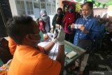 Warga terdampak pandemi COVID-19 mencairkan Bantuan Sosial Tunai (BST) di kantor Pos, Kota Kediri, Jawa Timur, Jumat (8/1/2020). Pemerintah menyiapkan anggaran sebesar Rp110 triliun pada tahun 2021 untuk bantuan sosial kepada masyarakt penerima manfaat di 34 provinsi guna membantu mengatasi dampak pandemi COVID-19 serta menggerakkan ekonomi nasional. Antara Jatim/Prasetia Fauzani/ZK