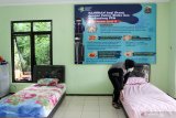Petugas merapikan tempat Isolasi mandiri di Kampung Tangguh Semeru perumahan Pucang Indah, Sidoarjo, Jawa Timur, Sabtu (9/1/2021). Menjelang Pemberlakuan Pembatasan Kegiatan Masyarakat (PPKM) di Pulau Jawa dan Bali 11-25 Januari mendatang, Polda Jawa Timur kembali merevitalisasi Kampung Tangguh Semeru sebagai upaya pengendalian dan pencegahan penyebaran COVID-19.  Antara Jatim/Umarul Faruq/ZK