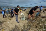 Relawan pemerhati lingkungan membersihkan sampah plastik dalam 'beach cleanup and brand audit' di Pantai Kedonganan, Badung, Bali, Sabtu (9/1/2021). Kegiatan tersebut untuk mengedukasi masyarakat mengenai bahaya sampah plastik bagi kehidupan laut yang digelar di lima titik pantai, yaitu Pantai Petitenget, Pantai Legian, Pantai Kuta, Pantai Jerman dan Pantai Kedonganan. ANTARA FOTO/Nyoman Hendra Wibowo/nym.