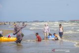 Sejumlah pengunjung menikmati wisata pantai angsana di Kabupaten Tanah Bumbu, Kalimantan Selatan, Minggu (10/1/2021). Pantai Angsana dengan jarak tempuh sekitar lima jam perjalanan darat dari Kota Banjarmasin merupakan salah satu obyek wisata andalan dan telah dikelola secara baik oleh Pemkab Tanah Bumbu sejak beberapa tahun terakhir ini. Foto Antaranews Kalsel/Bayu Pratama S.