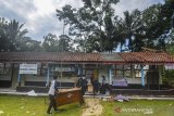 Siswa menyelamatkan barang-barang sekolah pasca ambruknya atap ruang kelas SDN 2 Janggala di Dusun Sukalilah, Kecamatan Cidolong, Kabupaten Ciamis, Jawa Barat, Senin (11/1/2021). Atap dua ruang kelas serta satu ruang guru di sekolah tersebut ambruk akibat diguyur hujan deras.  ANTARA JABAR/Adeng Bustomi/agr