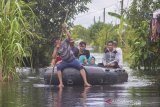 Relawan menggunakan perahu karet mengevakuasi warga yang terdampak banjir di Desa Banua Raya, Kabupaten Tanah Laut, Kalimantan Selatan, Senin (11/1/2021). Berdasarkan data yang telah di himpun aparat desa Banua Raya, sebanyak 2.907 Jiwa terdampak banjir akibat luapan sungai Bati Bati.Foto Antaranews Kalsel/Bayu Pratama S.