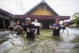 Warga menyelamatkan barang dari rumah yang terendam banjir di Desa Banua Raya di Kabupaten Tanah Laut, Kalimantan Selatan, Senin (11/1/2021).  Berdasarkan data yang telah di himpun aparat desa Banua Raya, sebanyak 2.907 Jiwa terdampak banjir akibat luapan sungai Bati Bati.Foto Antaranews Kalsel/Bayu Pratama S.