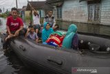 Relawan menggunakan perahu karet  mengevakuasi warga yang terdampak banjir di Desa Banua Raya, Kabupaten Tanah Laut, Kalimantan Selatan, Senin (11/1/2021). Berdasarkan data yang telah di himpun aparat desa Banua Raya, sebanyak 2.907 Jiwa terdampak banjir akibat luapan sungai Bati Bati.Foto Antaranews Kalsel/Bayu Pratama S.