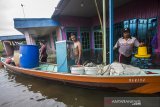 Warga menyelamatkan barang dari rumah yang terendam banjir di Desa Banua Raya, Kabupaten Tanah Laut, Kalimantan Selatan, Senin (11/1/2021). Berdasarkan data yang telah di himpun aparat desa Banua Raya, sebanyak 2.907 Jiwa terdampak banjir akibat luapan sungai Bati Bati.Foto Antaranews Kalsel/Bayu Pratama S.