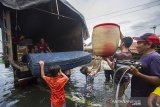 Warga menyelamatkan barang dari rumah yang terendam banjir di Desa Banua Raya, Kabupaten Tanah Laut, Kalimantan Selatan, Senin (11/1/2021). Berdasarkan data yang telah di himpun aparat desa Banua Raya, sebanyak 2.907 Jiwa terdampak banjir akibat luapan sungai Bati Bati.Foto Antaranews Kalsel/Bayu Pratama S.