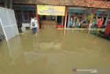 Petugas berada di sekitar kantor BPBD yang terendam banjir di Indramayu, Jawa Barat, Selasa (12/1/2021). Banjir tersebut akibat buruknya drainase dan tingginya intensitas hujan yang terjadi di wilayah Indramayu dan sekitarnya. ANTARA JABAR/Dedhez Anggara/agr