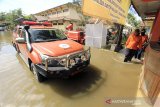 Petugas berada di sekitar kantor BPBD yang terendam banjir di Indramayu, Jawa Barat, Selasa (12/1/2021). Banjir tersebut akibat buruknya drainase dan tingginya intensitas hujan yang terjadi di wilayah Indramayu dan sekitarnya. ANTARA JABAR/Dedhez Anggara/agr