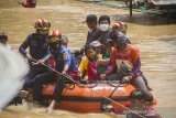 Petugas Badan Penanggulangan Bencana Daerah (BPBD) bersama relawan menggunakan perahu karet mengevakuasi warga yang terdampak banjir di Desa Sungai Raya, Kabupaten Banjar, Kalimantan Selatan, Selasa (12/1/2021).  Ribuan rumah di enam desa Kecamatan Simpang Empat Kabupaten Banjar terendam banjir setinggi 50 cm hingga dua meter akibat intensitas curah hujan yang tinggi sehingga mengakibatkan Sungai Riam Kiwa meluap.Foto Antaranews Kalsel/Bayu Pratama S.