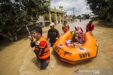 Relawan menggunakan perahu karet mengevakuasi warga yang terdampak banjir di Desa Sungai Raya, Kabupaten Banjar, Kalimantan Selatan, Selasa (12/1/2021). Ribuan rumah di enam desa Kecamatan Simpang Empat Kabupaten Banjar terendam banjir setinggi 50 cm hingga dua meter akibat intensitas curah hujan yang tinggi sehingga mengakibatkan Sungai Riam Kiwa meluap. Foto Antaranews Kalsel/Bayu Pratama S.