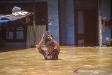 Seroang warga melintasi banjir di Desa Sungai Raya, Kabupaten Banjar, Kalimantan Selatan, Selasa (12/1/2021). Ribuan rumah di enam desa Kecamatan Simpang Empat Kabupaten Banjar terendam banjir setinggi 50 cm hingga dua meter akibat intensitas curah hujan yang tinggi sehingga mengakibatkan Sungai Riam Kiwa meluap. Foto Antaranews Kalsel/Bayu Pratama S.