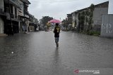 Pengendara motor melintasi genangan air di kawasan Tarogong Kidul, Kabupaten Garut, Jawa Barat, Rabu (13/1/2021). Hujan deras dan perbaikan drainase yang belum tuntas di kawasan tersebut mengakibatkan banjir menggenangi jalan setinggi 50 cm. ANTARA JABAR/Candra Yanuarsyah/agr