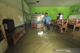 Sejumlah guru menyelamatkan barang di ruang kelas SDN Eretan Wetan 1 yang terendam banjir rob di Kandanghaur, Indramayu, Jawa Barat, Rabu (13/1/2021). Banjir rob akibat pasang air laut itu merendam ratusan rumah warga, bangunan sekolah dan mushola di kecamatan itu. ANTARA JABAR/Dedhez Anggara/agr